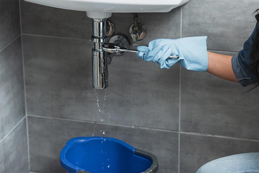 Plumber fixing leaking pipe